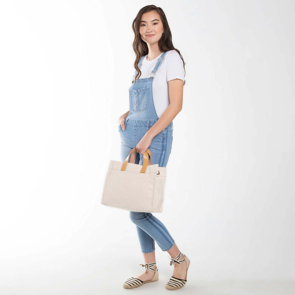 Person holding a White Canvas Utility Bag with Brown Leather Handles