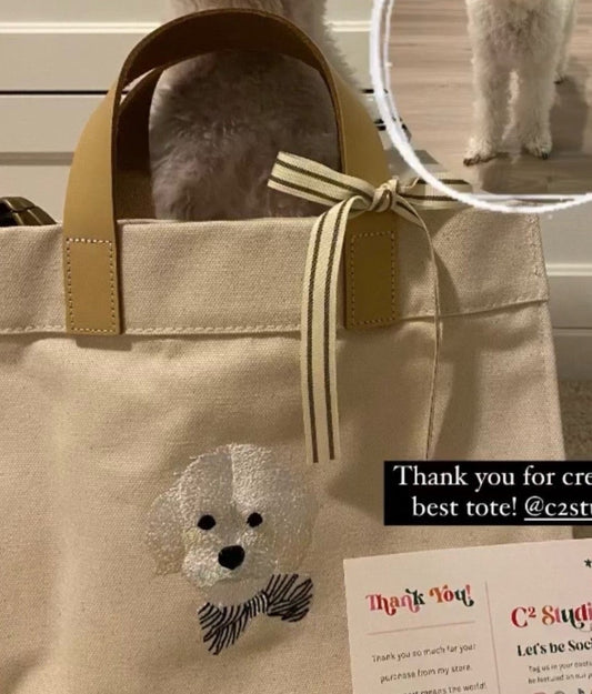 Close-up of a custom embroidered white dog portrait on a crossbody mini tote from a customer feedback
