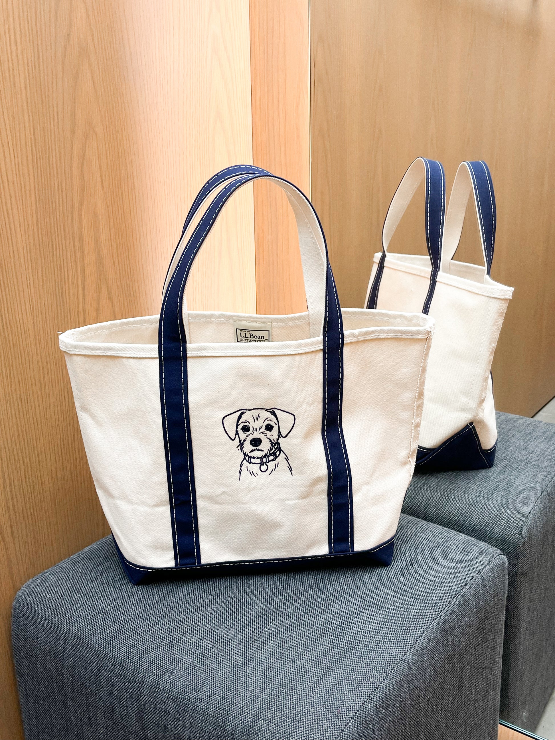 White tote bag with navy straps and an embroidered dog portrait