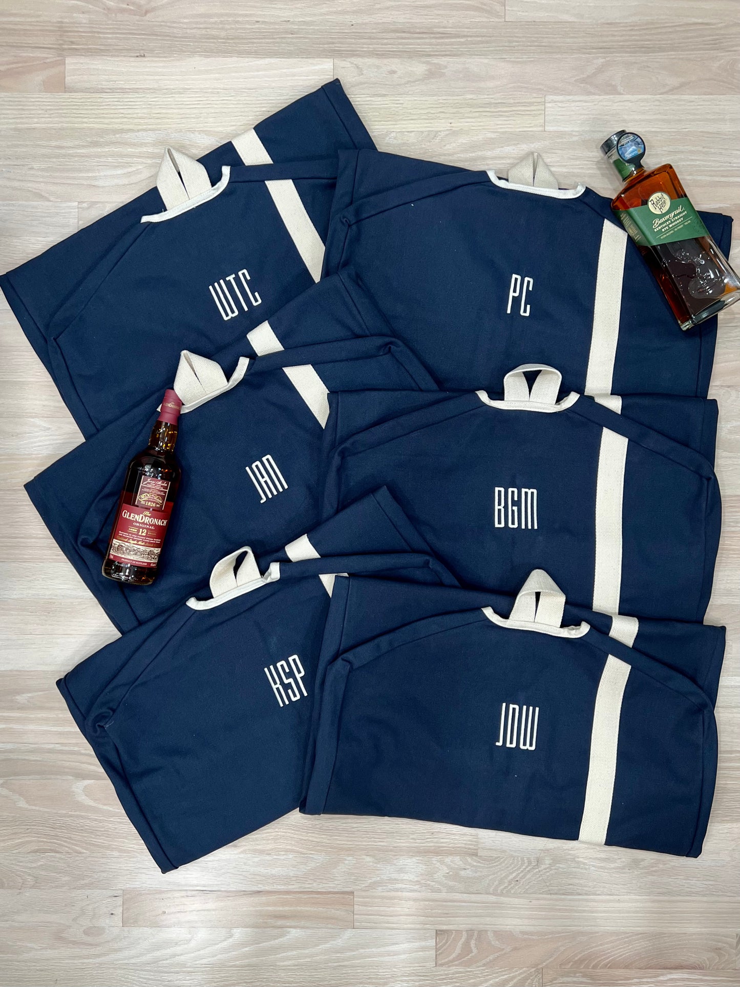 A collection of Navy blue and white Heavy Duty Garment Bags with embroidered monograms