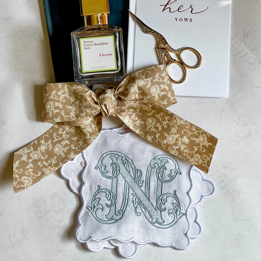 A set of white linen, scalloped edge, cocktail napkins with embroidered letter N monogram