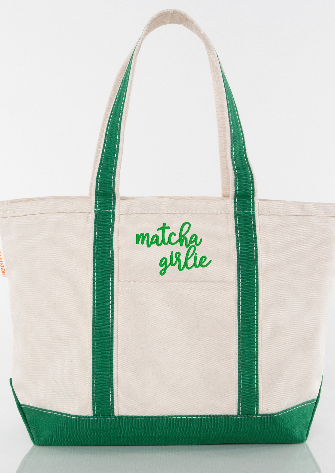 Beige tote bag with green handles and an embroidered 'matcha girlie' text
