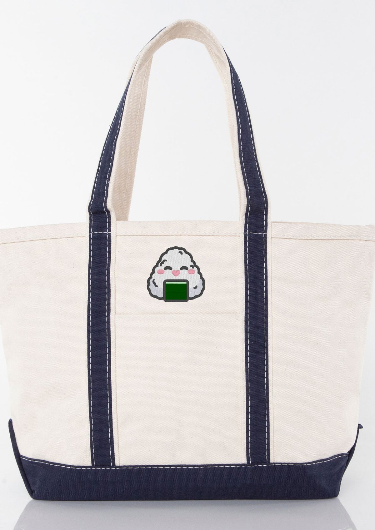 White tote bag with navy handles, featuring an embroidered onigiri design