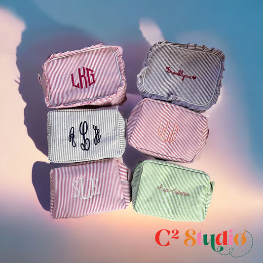A collection of personalized Seersucker Toiletry Bags with embroidered monogram designs