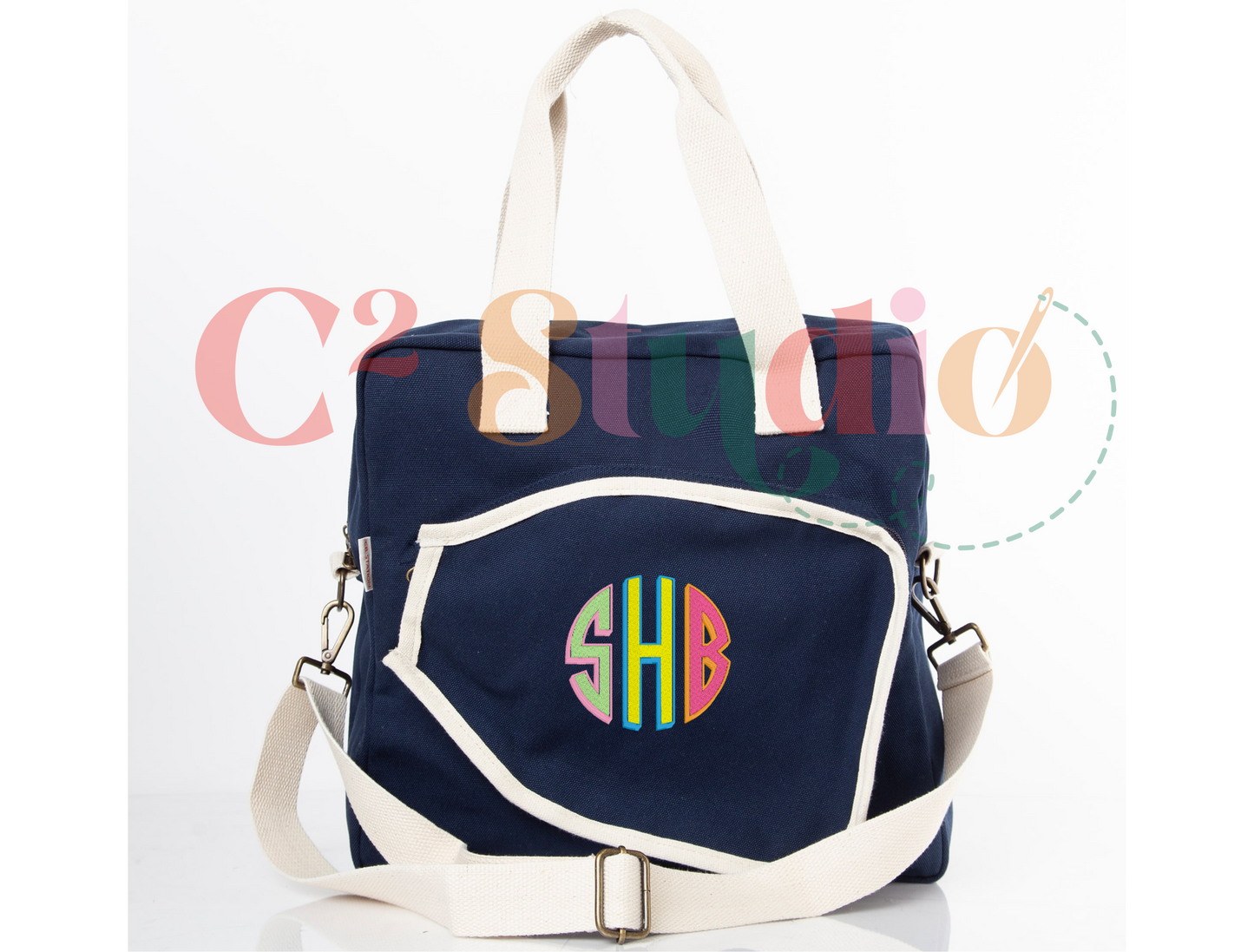 A navy and beige personalized pickleball bag with white handles and shoulder strap. The monogram "SHB" is embroidered on the front pocket.