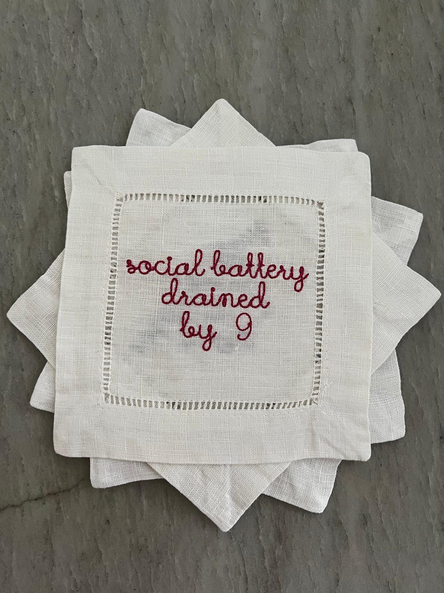 100% Linen Hemstitched Cocktail Napkin with embroidered 'Social Battery Drained by 9' in red text