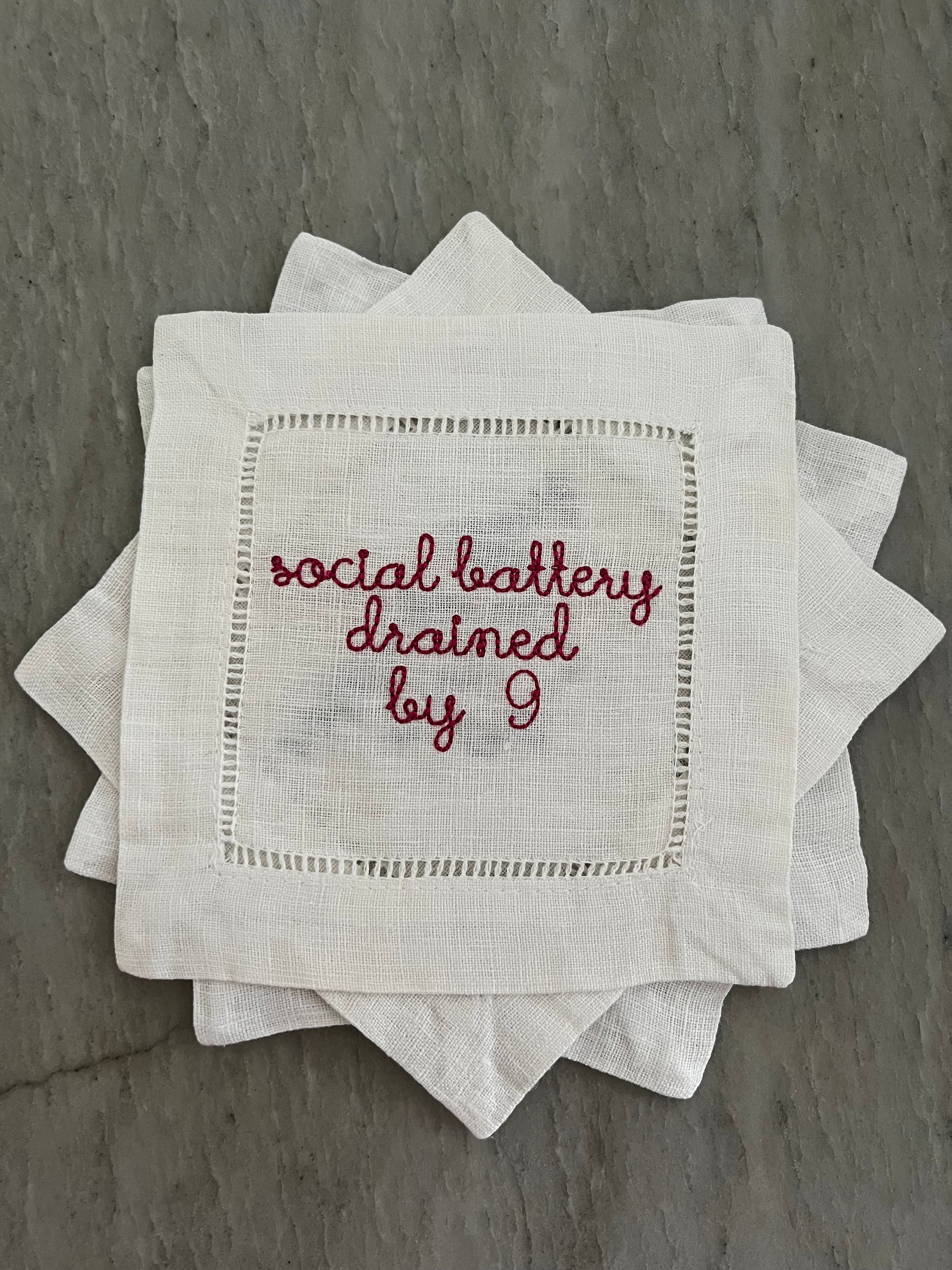 100% Linen Hemstitched Cocktail Napkin with embroidered 'Social Battery Drained by 9' in red text