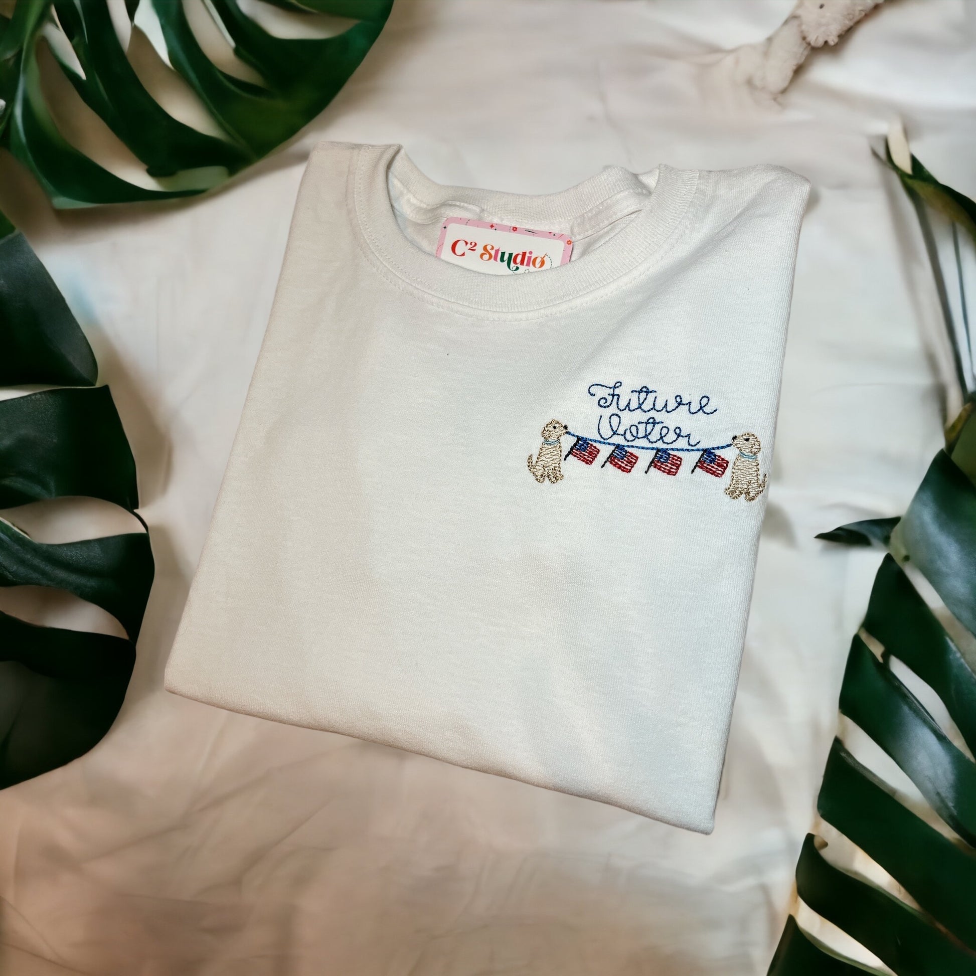100% Cotton White Long Sleeves T-shirt with a design that shows the text "Future Voter" with american flags held up by two dogs