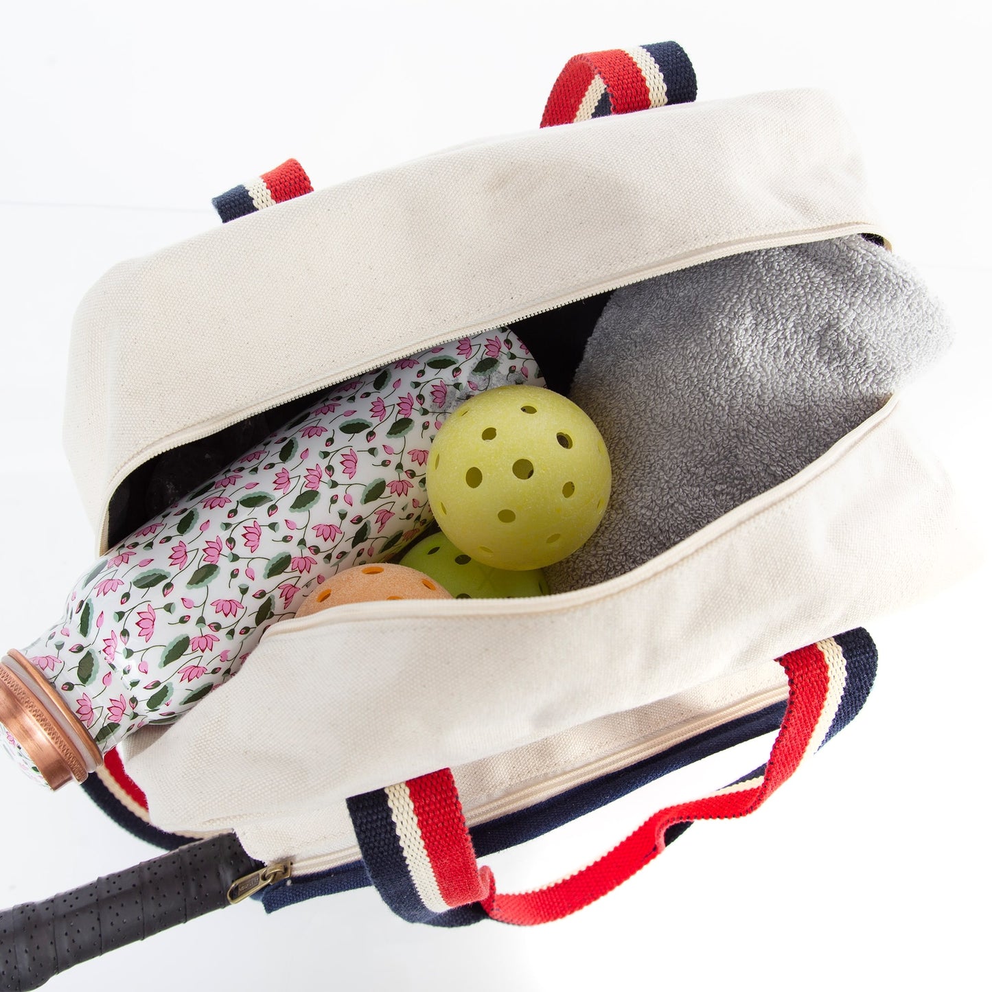Inside view of beige pickleball bag with red and navy blue striped handles